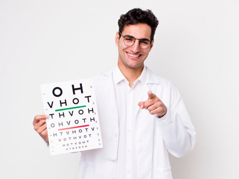 handsome hispanic man pointing at camera choosing you. optical vision test concept